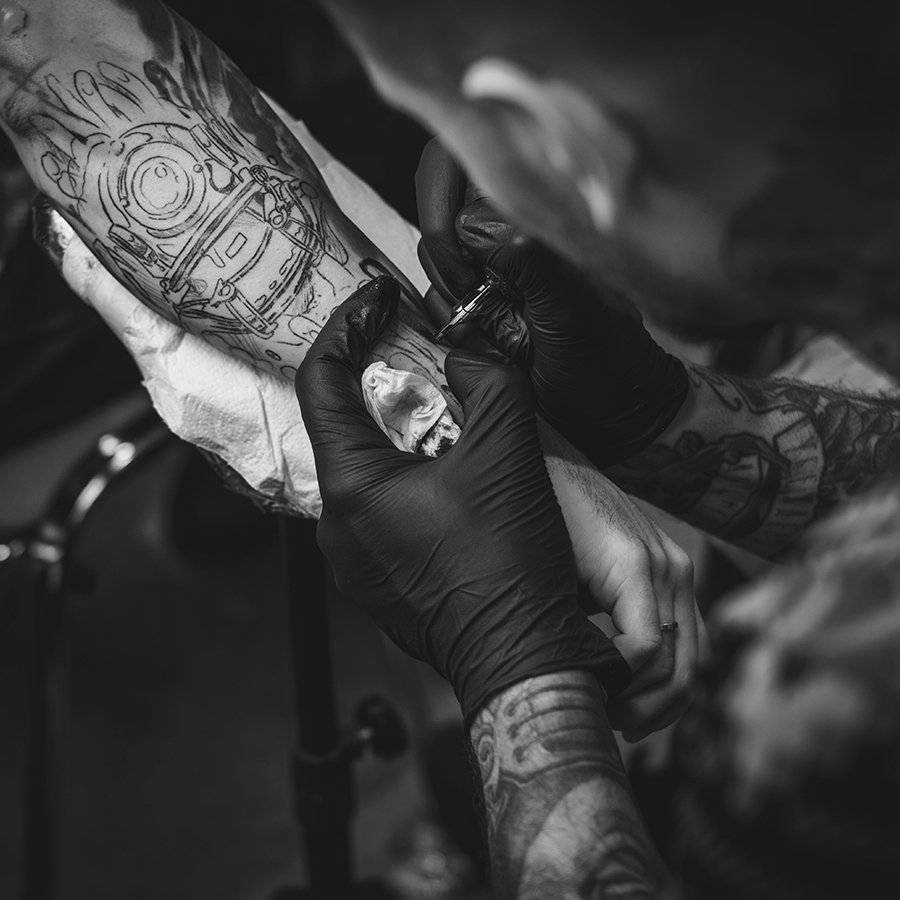 tattoo-artist-makes-a-tattoo-on-a-mans-hand-PKXBFS6.jpg